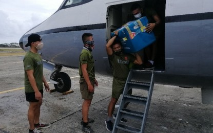 <p><strong>VACCINES FOR TAWI-TAWI.</strong> Marines and Air Force troops unload the boxes of vaccines from a Fokker plane of the Philippine Air Force (PAF) for the Integrated Provincial Health Office (IPHO) of Tawi-Tawi, the southernmost province of the country, on Thursday (March 11, 2021).  The delivery is the first batch of vaccines from the Department of Health. <em>(Photo courtesy of Western Mindanao Command Public Information Office)</em></p>
