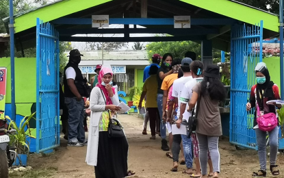 <p><strong>PALAWAN DECIDES.</strong> Residents queue up at the Rio Tuba South Elementary School in Bataraza town, southern Palawan on Saturday (March 13, 2021) to vote in the plebiscite that will determine whether or not the province would be divided into three separate local government units. Bataraza is among the municipalities with the highest number of registered voters in Palawan. <em>(Photo by Celeste Anna Formoso)</em></p>