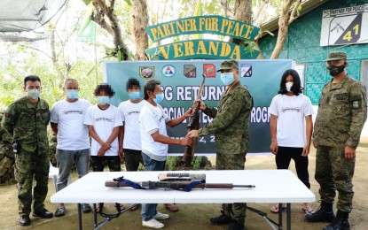 <p><strong>5 MORE SURRENDERERS.</strong> An Abu Sayyaf Group surrenderer hands over a Garand rifle to Brig. Gen. Antonio Bautista Jr., the Army's 1101st Infantry Brigade commander, during a ceremony on Friday (March 12, 2021). Four other bandits surrendered to the Army's 41st Infantry Battalion, headed by Lt. Col. James Erasmus Gagni (right) in Barangay Matatal, Maimbung, Sulu. <em>(Photo courtesy of the 11th infantry Division Public Information Office)</em></p>