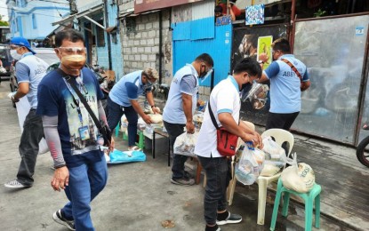 <p><strong>LOCKDOWN.</strong> Makati City Hall staff distribute food packs in Barangay Pio del Pilar areas that are under localized enhanced community quarantine from Saturday (March 13, 2021) until 11:59 p.m. on Tuesday (March 16, 2021). Barangay Pio del Pilar has 123 Covid-19 active cases, the highest in the city’s 1st District as of March 11. <em>(Photo courtesy of Makati-PIO)</em></p>