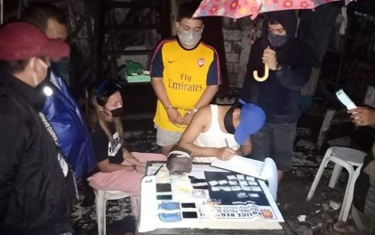 <p><strong>DRUG HAUL.</strong> An operative of Police Regional Office-Western Visayas Drug Enforcement Unit conducts an inventory of suspected shabu seized from high-value individual Mark Dayon and Conilyn Rose Chavez in Purok Kagaykay, Barangay 2 in Bacolod City on Saturday (March 13, 2021). The suspects yielded 15 sachets of shabu weighing 75 grams with an estimated value of PHP525,000<em>. (Photo courtesy of Bacolod City Police Office)</em></p>
