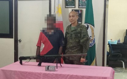 <p><strong>SURRENDER.</strong> BIFF bombmaker and sniper Tong Dubpalig yields his .50 caliber Barrett sniper rifle following his surrender Sunday (March 14, 2021) to Lt. Col. Edgardo Vilchez Jr., Army’s 34IB chief, in Midsayap, North Cotabato. Dubpalig belonged to the BIFF-Karialan faction that is believed responsible for the string of bombing incidents in Central Mindanao the past several years. <em>(Photo courtesy of 34IB)</em></p>