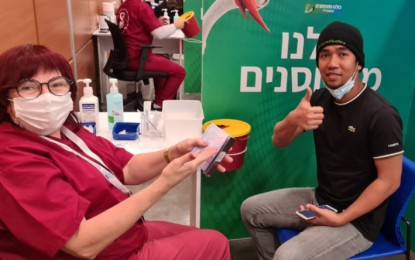 <p><strong>VACCINATED.</strong> A Filipino national shows his Philippine passport to a health worker for his free Covid-19 vaccine shot in this undated photo. The Israeli government has so far inoculated more than half of its population or some 5.2 million people, including thousands of overseas Filipinos, especially caregivers. <em>(Photo courtesy of Israel Embassy)</em></p>