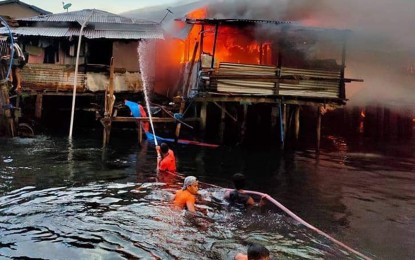 <p><strong>CONFLAGRATION.</strong> Firefighters from the Philippine Coast Guard assist the Bureau of Fire Protection firemen in putting out the fire that hit Saturday (March 20, 2021), a coastal community in Barangay Baliwasan, Zamboanga City. The incident displaces some 500 individuals who are temporarily sheltered at the covered court of the Baliwasan Central Elementary School. <em>(Photo courtesy of PCG-Zamboanga)</em></p>