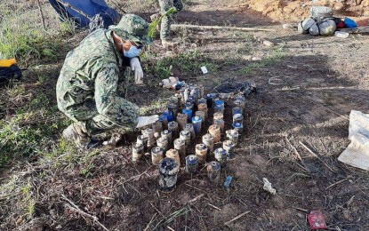 <p><strong>IED CLEARING OPS.</strong> A police officer checks IED components seized during clearing operations in Barangay Dumagmang, Labo, Camarines Norte on Monday (March 22, 2021). The PNP has recommended the closure of all illegal mining operations in Camarines Norte after it discovered that some IED components used by NPA members in last week's encounter with police officers came from illegal mining sites in the area. <em>(Photo courtesy of PNP)</em></p>
