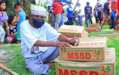 <p><strong>SURVIVING THE CONFLICT.</strong> An old man displaced by armed hostilities in Barangay Kitango, Datu Saudi Ampatuan, Maguindanao, holds on to boxes of relief goods he received from the MSSD-BARMM. The military said that the fighting, which started on March 18, had subsided and that clearing operations are ongoing in an area where the BIFF operates. <em>(Photo courtesy of BIO-BARMM)</em></p>