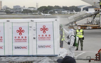 <p><strong>VACCINE ARRIVAL</strong>. A personnel wearing personal protective equipment disinfects the boxes of 400,000 doses of China-donated CoronaVac vaccine before they are transferred to a cold delivery truck at the Ninoy Aquino International Airport (NAIA) Terminal 2 in Pasay City on Wednesday (March 24, 2021). The additional vaccine doses brings to one million the total CoronaVac jabs donated by the Chinese government to the Philippines. . <em>(PNA photo by Avito C. Dalan)</em></p>