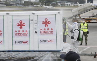 <p><strong>LIFE-SAVING DOSES.</strong> An airport personnel disinfects the cargo carrying the CoronaVac vaccines. About 400,000 doses of the Sinovac-manufactured jabs arrived at the Ninoy Aquino International Airport on Wednesday (March 24, 2021). <em>(PNA photo by Avito C. Dalan)</em></p>
