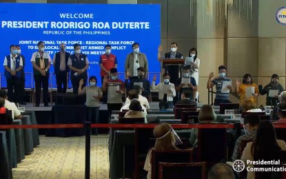 <p><strong>ADDRESSING INSURGENCY.</strong> Department of Human Settlements and Urban Development (DHSUD) Secretary Eduardo del Rosario facilitates the oath-taking of rebel returnees elected as officers of a regional federation of former rebels in Eastern Visayas on March 18, 2021. The insurgency has been hampering economic development in the region but the RTF-ELCAC-8 has been making strides in its efforts toward exclusive and sustainable peace. <em>(Screengrab from RTVM)</em></p>