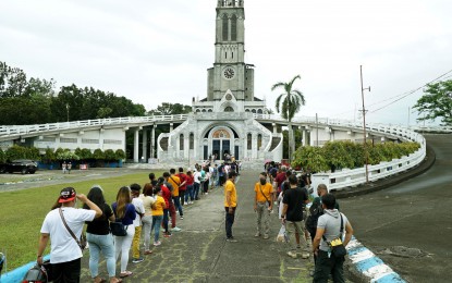 <p><strong>NO HOLY WEEK ACTIVITIES.</strong> Photo taken of devotees on March 14, 2021 waiting for their turn to enter inside Our Lady of Lourdes Shrine in Barangay Graceville, Sta Maria Road, San Jose Del Monte City, Bulacan for the 4th Sunday of Lent mass on March 14, 2021. The Shrine of Our Lady of Lourdes Grotto (SOLLG) said on its website that the church will be closed until April 11 after Bulacan, Metro Manila, Cavite, Laguna, and Rizal were placed under stricter general community quarantine until April 4 due to Covid19 cases surge. <em>(PNA photo by Ben Briones)</em></p>