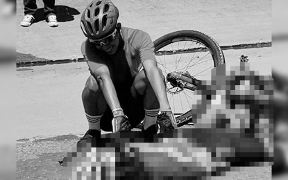 <p><strong>ROAD MISHAP</strong>. A biker checks his fellow cyclist ran over and killed by a truck after losing balance and fell on the road in Tacloban City in this March 16, 2021 photo. The interagency technical working group (TWG) on active transport has reiterated its call on Thursday (March 25, 2021) to build protected bicycle lane networks to ensure the safety of cyclists. <em>(Photo courtesy of Albert Eviota)</em></p>