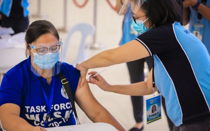 <p><strong>VACCINATION</strong>. A member of the Covid-19 response teams in the City of San Fernando, Pampanga receives the first dose of vaccine against Covid-19 at the Mini Convention Hall, Heroes Hall on Friday (March 26, 2021). A total of 300 front-liners have been inoculated since the arrival of the vaccines on March 21, 2021.<em> (Photo by the City Government of San Fernando)</em></p>