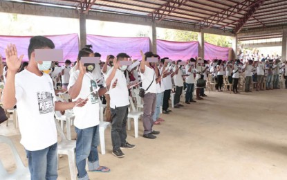 <p><strong>PLEDGE OF ALLEGIANCE.</strong> At least 304 militiamen and supporters of the communist New People’s Army take the oath of allegiance to the government in a ceremony held Friday (March 26, 2021) in Barangay Ibuan, Las Nieves, Agusan del Norte. The barangay has been known for decades as a 'mass base' of the communist rebels. <em>(Photo courtesy of 23IB)</em></p>