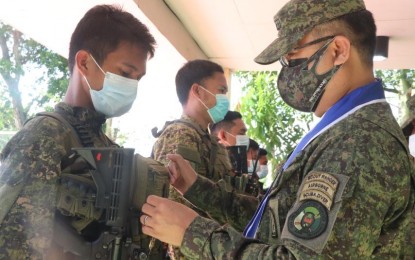 <p><strong>MEDAL OF MERIT</strong>. Armed Forces of the Philippines chief of staff, Lt. Gen. Cirilito Sobejana (right), awards the military merit medal to 80 officers and enlisted personnel of the Philippine Army at the 62nd Infantry Battalion headquarters in Barangay Libas, Isabela, Negros Occidental last Thursday (March 25, 2021). The 80 soldiers fought with some 40 NPA rebels in central Negros on March 23 that left 10 communist terrorist fighters dead and one wounded. <em>(Photo courtesy of 62nd Infantry Battalion, Philippine Army)</em></p>