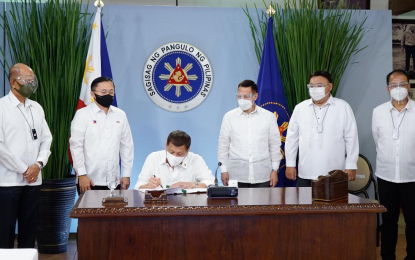 <p><strong>ECQ AID</strong>. President Rodrigo Roa Duterte signs the proposed grant of financial assistance to the local government units placed under the enhanced community quarantine following the meeting with the Inter-Agency Task Force on the Emerging Infectious Diseases (IATF-EID) core members in Malacañang on Monday night (March 29, 2021). Witnessing the signing are (L-R) Defense Secretary Delfin Lorenzana, Senator Christopher Lawrence Go, Health Secretary Francisco Duque III, Presidential Spokesperson Herminio "Harry" Roque Jr., and Presidential Adviser on Peace Process and National Task Force against Coronavirus Disease-2019 (NTF Covid-19) chief implementer, Secretary Carlito Galvez Jr. <em>(Presidential photo by King Rodriguez)</em></p>