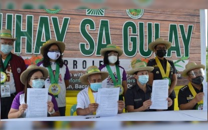 <p><strong>PARTNERSHIP</strong>. Officials led by Department of Agrarian Reform-6 regional director Sheila Enciso (seated, left) and Senior Supt. Gilbert Peremne (seated, right), assistant regional director of Bureau of Jail Management and Penology-6, attend the launching of the “Buhay sa Gulay” project in Barangay Alangilan, Bacolod City on Monday (March 29, 2021). The Benez Agrarian Reform Beneficiaries Farmers Association has been identified as the pilot site for the project implementation in Western Visayas. <em>(Photo courtesy of DAR Negros Occidental I-North)</em></p>