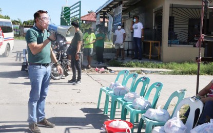 <p><strong>ASSISTANCE</strong>. Mayor Enrico Roque of Pandi, Bulacan leads the first day of distribution of food packs in Barangay Bagong Barrio on Tuesday, (March 30, 2021), following the reimplementation of the enhanced community quarantine (ECQ) in the NCR Plus bubble, which includes the province of Bulacan from March 29 to April 4, 2021. Some 16,000 families from six villages in Pandi have so far received food packs at the start of the distribution. <em>(Photo by Manny Balbin)</em></p>