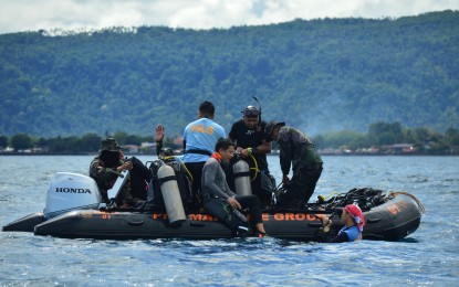 <p><strong>SEA BED CLEANUP</strong>. Policemen led by Lt. Col. Mardy Hortillosa, spokesperson of the Police Regional Office-10, prepare to dive during a cleanup activity on Tuesday (March 30, 2021) to remove fishing nets stuck on the sea bed at Puntod Shoal, Barangay San Juan, Gingoog City. The cleanup drive dubbed as “Scubasurero” is ongoing as police officers and civilian divers are working hand in hand to clear the area of fishing nets and trash.<em> (PNA photo by Jigger J. Jerusalem)</em></p>