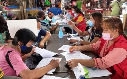 <p><strong>NO POLITICS IN ‘AYUDA’.</strong> Social welfare personnel assist beneficiaries of a livelihood assistance grant in Alimodian, Iloilo in this undated photo. The Department of the Interior and Local Government has warned against the use of a politician’s name, photo, or image in the distribution of aid worth PHP1,000 per individual, or a maximum of PHP4,000 per family, in the NCR Plus, which is under enhanced community quarantine. <em>(Photo courtesy of DSWD)</em></p>