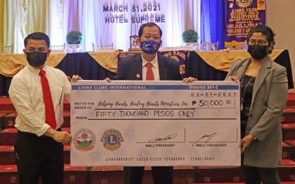 <p><strong>HELP FOR SICK CHILDREN</strong>. The Metro Baguio Lions Club led by its president Jaime Tee (middle) turns over to Helping Hand Healing Heart Ministries  assistant director Marissa dela Peña a replica of a check as payment for 46 paintings of children with cancer sold by the organization. An exhibit/auction was held during the club’s induction of officers on Wednesday (March 31, 2021) at the Hotel Supreme in Baguio City.<em> (Photo courtesy of Lions Club)</em></p>