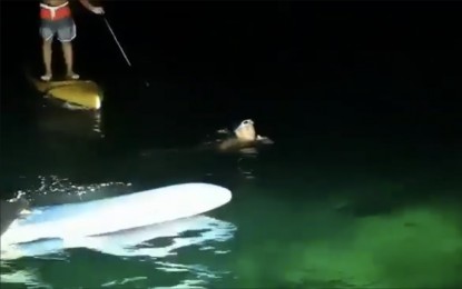 <p><strong>12 HOURS AT SEA.</strong> This photo shared on Monday (April 5, 2021) by Lapu-Lapu City Mayor Junard Chan shows swimmer Cleevan Alegres being greeted by local residents. Alegres completed a full swim around Olango Island at 3:30 a.m. on Monday after he circumnavigated the islet for 12 hours. <em>(Screenshot from shared video)</em></p>