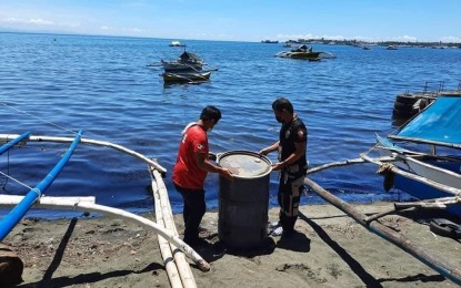 <p><strong>OIL SPILL.</strong> Barangay volunteers of Lower Jasaan, Jasaan town, Misamis Oriental, clean up oil that was spilled when a cargo ship sank Saturday morning. Residents are advised not to bathe or go fishing until the spill is fully contained. <em>(Photo courtesy of Sabas Tagarda Jr.)</em></p>