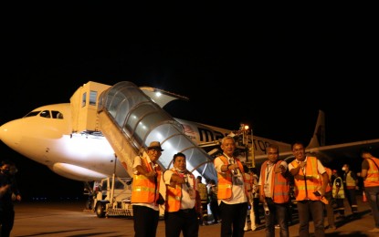 <p><strong>DAIRY GOATS.</strong> Officials of the Department of Agriculture-Region 12 led by Regional Executive Director Arlan Mangelen (center) and other government representatives make the fist bump gesture in front of a Malaysia Airlines cargo plane that delivered some 1,285 dairy goats from Australia at the General Santos City international airport on Monday night (April 5, 2021). The milking goats are acquired by the National Dairy Authority under the expanded Intensified Community Based Dairy Enterprise Development project supported by the United States Department of Agriculture. (<em>Photo courtesy of DA-12</em>)   </p>