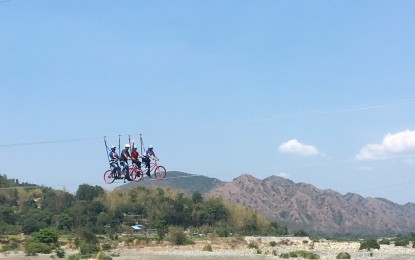 <p><strong>BIKE IN THE SKY.</strong> Adventure junkies try the bike zipline in Sitio Bucana, Barangay Parparoroc, Vintar, Ilocos Norte in this undated photo. The Vintar government is temporarily banning non-residents from its tourism facilities and attractions until further notice. <em>(PNA file photo by Leilanie G. Adriano)</em></p>