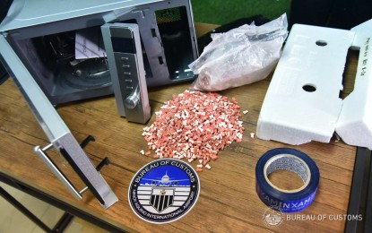 <p><strong>HIDDEN PACKAGE.</strong> Customs officers seize PHP2.86 million worth of ecstasy tablets concealed in a microwave oven at the Port of NAIA in Pasay City on Tuesday (April 6, 2021). The BOC also seized over PHP159,000 worth of kush or high grade marijuana hidden in another parcel. <em>(Photo courtesy of BOC)</em></p>