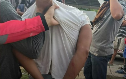 <p><strong>ARRESTED.</strong> Police officers collar drug suspect Dido Alim Silongan in a buy-bust in Barangay Mother Tamontaka, Cotabato City Wednesday (April 7, 2021). The suspect sustained a bullet wound after he allegedly attempted to grab the firearm of one of the members of the arresting team. <em>(Photo courtesy of Brigada News FM Cotabato)</em></p>