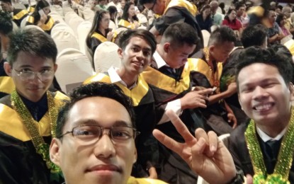 <p><strong>VICTORY</strong>. Achilles Cabaron Jr., a beneficiary of the Special Program for the Employment of Students of the Department of Labor and Employment, poses for a groufie with his batchmates during his graduation in 2019. Enjoying the fruits of his hard work, the young Cebuano is now a college instructor at the Cebu Technological University-Main Campus in Cebu City.<em> (Photo courtesy of DOLE-7)</em></p>