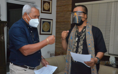 <p><strong>NEW MANDATE.</strong> Cagayan de Oro City Mayor Oscar Moreno (left) congratulates Nicolas Aca, a prominent local performance artist, after being sworn in as the new chairperson of the City's Historical and Cultural Commission on Tuesday (April 13, 2021). In an interview Wednesday, Aca says he plans to continue the pending projects that his predecessor started, such as the reconstruction of the Museo de Oro. <em>(Photo courtesy of City Information Office)</em></p>