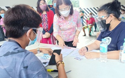 <p><strong>CASH AID.</strong> A Pasay City resident receives PHP4,000 on April 9, 2021 under the national government’s assistance program for residents in areas under enhanced community quarantine. The city has received PHP348 million for the grant of emergency assistance to its qualified residents. <em>(Photo courtesy of Pasay-PIO)</em></p>