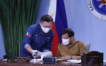 <p><strong>AT WORK.</strong> Senator Bong Go confers with President Rodrigo Duterte during the Cabinet meeting in Malacañang on Thursday (April 15, 2021). The meeting tackled, among others, further measures to contain the Covid-19 pandemic and the vaccine rollout. <em>(Photo courtesy of SBG)</em></p>