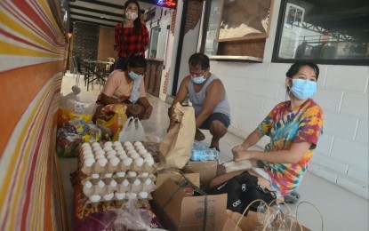 <p><strong>BAYANIHAN ALIVE.</strong> Volunteers help repack food and other items in a community pantry on Maginhawa Street, Quezon City on Friday (April 16, 2021). Malacañang lauded the brains behind the pantries, where the needy can get supplies for free. <em>(PNA photo by Robert Oswald P. Alfiler)</em></p>