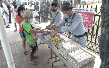 <p><strong>JOINT EFFORT.</strong> Intramuros, Manila joins the community pantry fray on Monday (April 19, 2021). Tables are set up outside the Manila Cathedral with assorted food items being distributed with the help of two security personnel. <em>(PNA photo by Avito C. Dalan)</em></p>