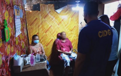 <p><strong>‘FAKE’ DENTIST</strong>. Criminal Investigation and Detection Group-South Cotabato operatives question unlicensed dentist Paz Magluyan Lopez, 64 (seated, left), during a raid on her “illegal clinic” in Barangay Zone 2, Koronadal City before noon Tuesday (April 20, 2021). Lopez, who has reportedly practiced illegally for over 10 years, was caught while extracting a tooth of a male patient (seated, right)<em>. (Photo courtesy of CIDG-South Cotabato)</em></p>