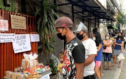 <p><strong>HELPING THE NEEDY.</strong> People line up to get food items at the community pantry along Gov. Pascual-Baritan Road in Malabon City on Monday (April 19, 2021). The initiative was the brainchild of Malabon resident Nina Louise Tesorero and her friends who are behind 'Project Pay it Forward'. <em>(Photo courtesy of Nina Louise Tesorero)</em></p>