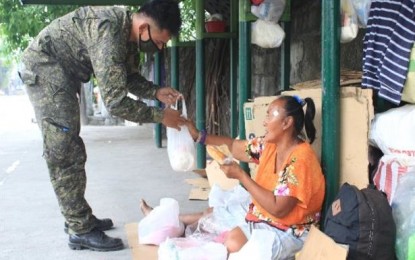 <p><strong>LENDING A HAND.</strong> A soldier gives a food pack to a homeless woman in this undated photo. The AFP, through its Civil Relations Service, has extended assistance to over 653,000 households through various humanitarian efforts since the start of the coronavirus pandemic. <em>(Photo courtesy of AFP)</em></p>