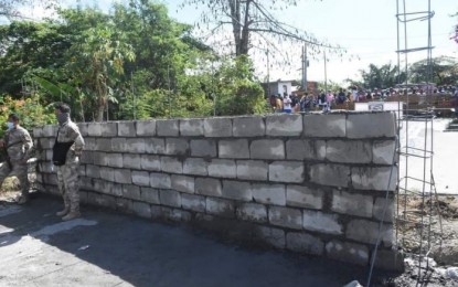 <p><strong>SAFETY REASONS.</strong> The Bureau of Corrections is not backing down on its decision to build this wall to block an access road to the New Bilibid Prison in Muntinlupa City. Justice Secretary Menardo Guevarra said on Friday (April 23, 2021) officials would conduct an ocular inspection at a still undetermined date.<em> (Photo courtesy of Muntinlupa-PIO)</em></p>