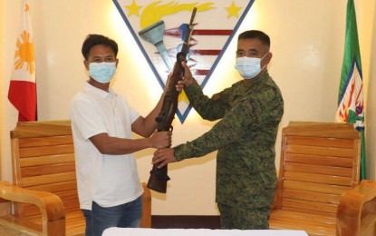 <p><strong>ANOTHER ASG SURRENDERER.</strong> Abdul Asnula Akil, a member of the Basilan-based Abu Sayyaf Group (ASG), hands over a Garand rifle to Brig. Gen. Domingo Gobway, Joint Task Force Basilan commander, when he surrendered Sunday (April 25, 2021) in Basilan province. Akil is the 11th ASG member who surrendered in Basilan in January 2021. <em>(Photo courtesy of the Western Mindanao Command Public Information Office)</em></p>