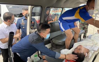 <p>Senator Christopher Lawrence “Bong” Go talks to one of the three injured passengers of a Philippine Air Force helicopter crash inside an ambulance at the Mactan-Benito Ebuen Air Base in Cebu on Tuesday. (<em>Contributed photo</em>)</p>
<p> </p>