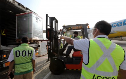<p><strong>SECURING JABS.</strong> National Task Force Against Covid-19 Chief Implementer Secretary Carlito Galvez Jr. (right), oversees the loading of 500,000 doses of government-procured CoronaVac vaccines on the refrigerated van at the NAIA Terminal 2 on Thursday (April 29, 2021). By June, the government is looking at a steady stockpile of nearly 10 million doses of Covid-19 vaccines from pharmaceutical firms Sinovac, Moderna, Gamaleya Research Institute and Oxford/AstraZeneca.<em> (PNA photo by Joey O. Razon)</em></p>