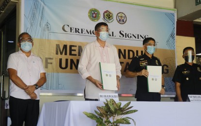 <p><strong>PARTNERSHIP</strong>. Department of Health-Bicol regional director Dr. Ernie Vera (2nd from left) and Bureau of Fire Protection (BFP)-Bicol chief, Sr. Supt. Renato B. Capuz (2nd from right) show their signed copies of a memorandum of understanding for strengthening the region's fight against Covid-19. The two agencies' joint program dubbed "On the Road Bandillo" will involve the deployment of firetrucks to broadcast DOH's campaign against the dreaded virus.<em> (Photo courtesy of DOH-Bicol)</em></p>