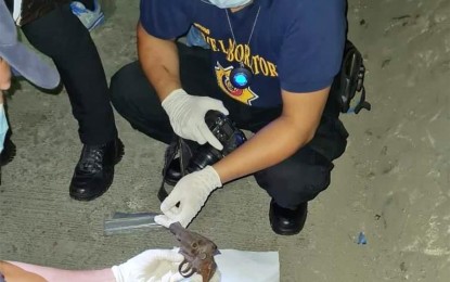 <p><strong>KILLED.</strong> Police investigators examine the caliber .38 revolver used by the slain drug suspect, Raffy Ledesma Concepcion, in a buy-bust operation in Marilao, Bulacan at about 12:20 a.m. Friday, (April 30, 2021). Another 18 drug suspects were arrested in separate operations in the province.<em> (Photo courtesy of Marilao PNP)</em></p>