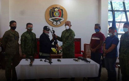 <p><strong>PRIVATE ARMED GROUP SURRENDER</strong>. Mayor Salik Mamasabulod (3rd from left) hands over a firearm to PRO-BARMM Director, Brig. Gen. Eden Ugale, during the formal surrender rites of the mayor and his private armed group at the regional police headquarters in Parang, Maguindanao on Friday (April 30, 2021). The Mamasabulod armed group surrendered four high-powered firearms. <em>(Photo courtesy of PRO-BARMM)</em></p>