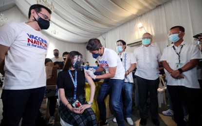 <p><strong>LABOR DAY GIFT.</strong> Manila Health Department chief Dr. Arnold Pangan inoculates a front-liner in the essential industry on Saturday (May 1, 2021) at the Palacio de Maynila in Malate. The activity was part of Labor Day celebrations. <em>(PNA photo by Joey Razon)</em></p>