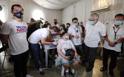 <p><strong>OFW JABS</strong>. Manila Health Department chief, Dr. Arnold Pangan (2nd from left), administers the Sinovac vaccine to overseas Filipino worker (OFW) Cristina David, during the simultaneous symbolic vaccination of OFW and minimum wage workers in line with the Labor Day celebration at the Palacio De Manila in Manila City on Saturday (May 1, 2021). Also in photo are Labor and Employment Secretary Silvestre "Bebot" Bello III (3rd from right), Trade and Industry Secretary Ramon Lopez (2nd from right), Technical Education and Skills Development Authority chief Isidro Lapeña (right), and Manila Mayor Francisco "Isko Moreno" Domagoso (left).<em> (PNA photo by Joey O. Razon) </em></p>