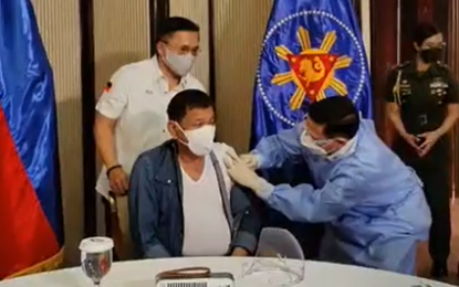 <p><strong>STILL TO GET 2ND DOSE.</strong> President Rodrigo Duterte receives his first shot of a Sinopharm Covid-19 vaccine on Monday night (May 3, 2021). Malacañang on Thursday (May 6) said Duterte is still scheduled to receive his second dose of the vaccine despite his order to pull out Sinopharm jabs over concerns that the vaccine has yet to receive an emergency use authorization (EUA) from local regulators.<em> (Screenshot from Senator Bong Go’s Facebook livestream)</em></p>