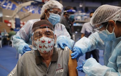 <p><strong>PROTECTED.</strong> An elderly man receives his first dose of the Sputnik V vaccine during the rollout of the Russian-made jab at the Makati Coliseum in Makati City on May 13, 2021. Senior citizens who are listed under the A2 group of the government's vaccination priority sectors are among the recipients of the first tranche of 15,000 doses of the government-procured Sputnik V vaccines.<em> (PNA photo by Jess M. Escaros Jr.)</em></p>